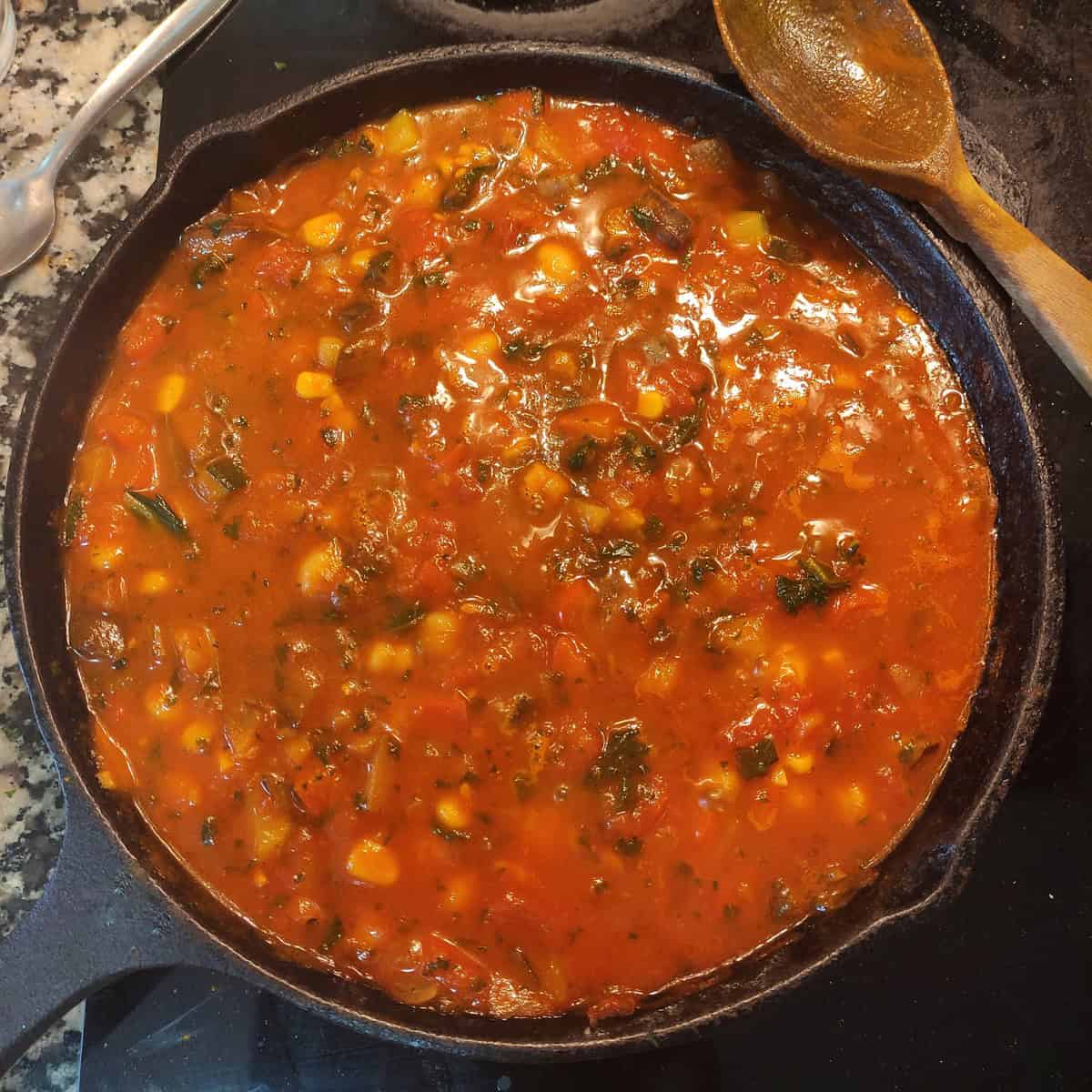 A cast iron skillet of the chickpea and vegetable lasagna filling ready to be layed with the pasta sheets.
