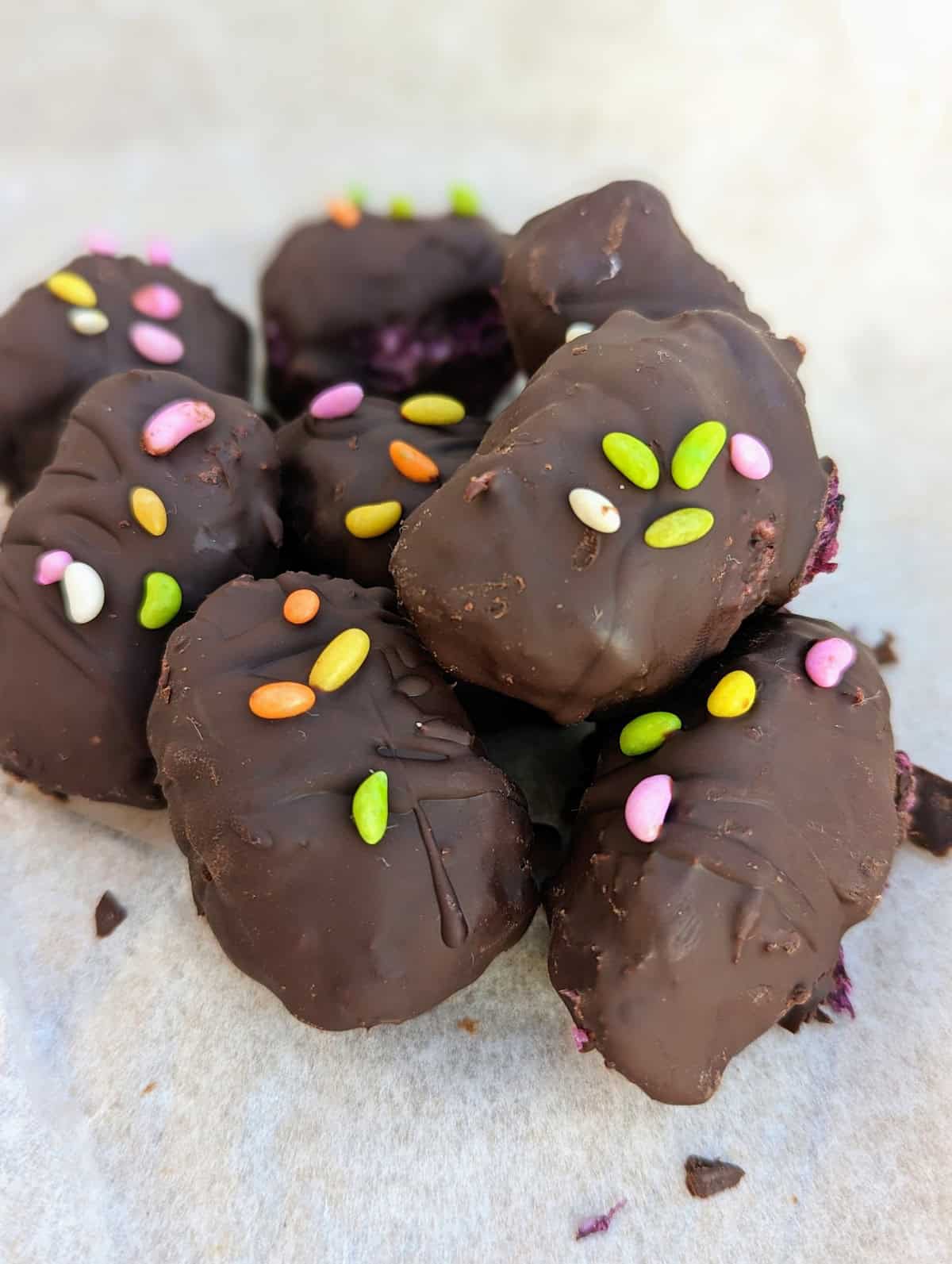 A close up of Chocolate Bounty Blueberry Bites topped with sugar-coated fennel seeds.