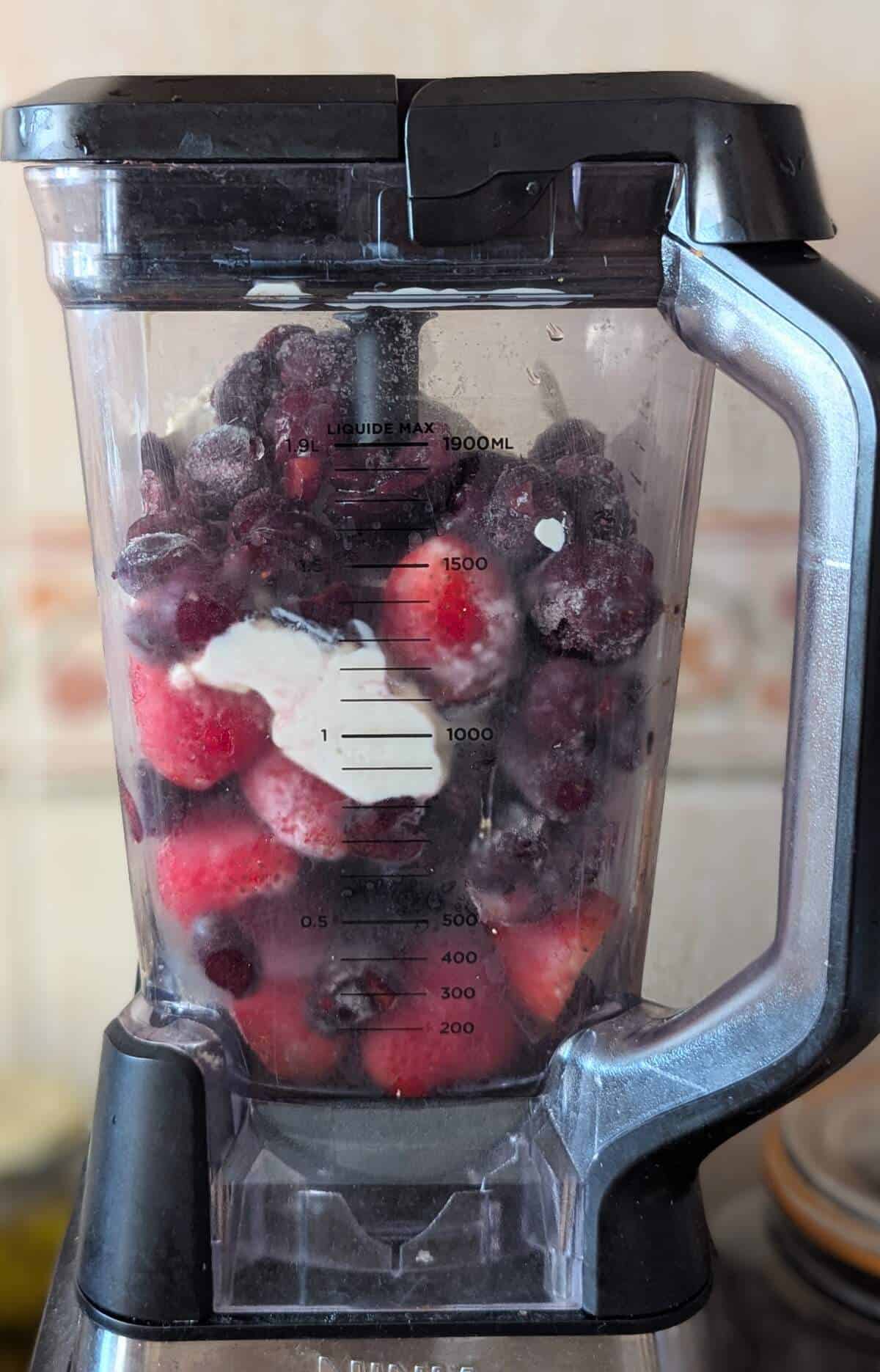 Frozen cherries, strawberries and yoghurt in a blender.
