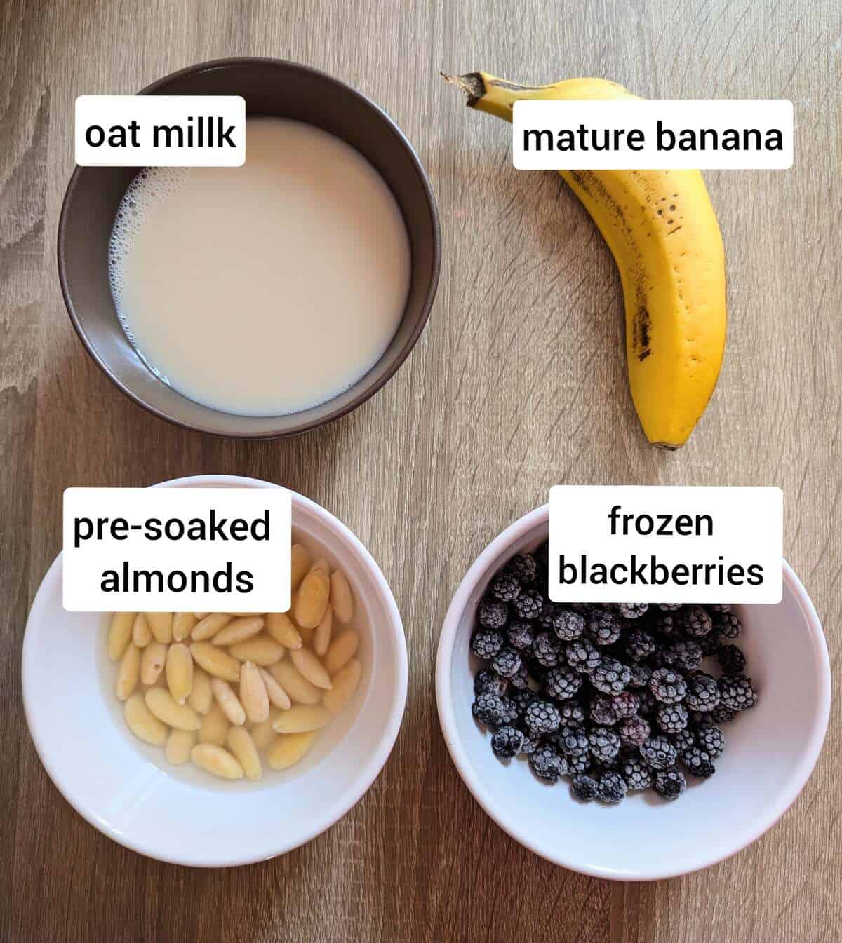 Blackberry smoothie ingredients: pre-soaked almonds, frozen blackberries, oat milk and a banana.