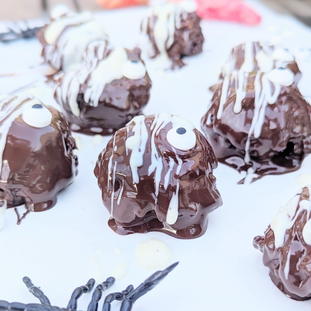 Scary one-eyed chocolate monster balls on a white marble table.
