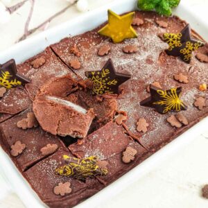 Decorative vegan chocolate mint fudge cake with star-shaped chocolate toppers and cocoa powder dusting.