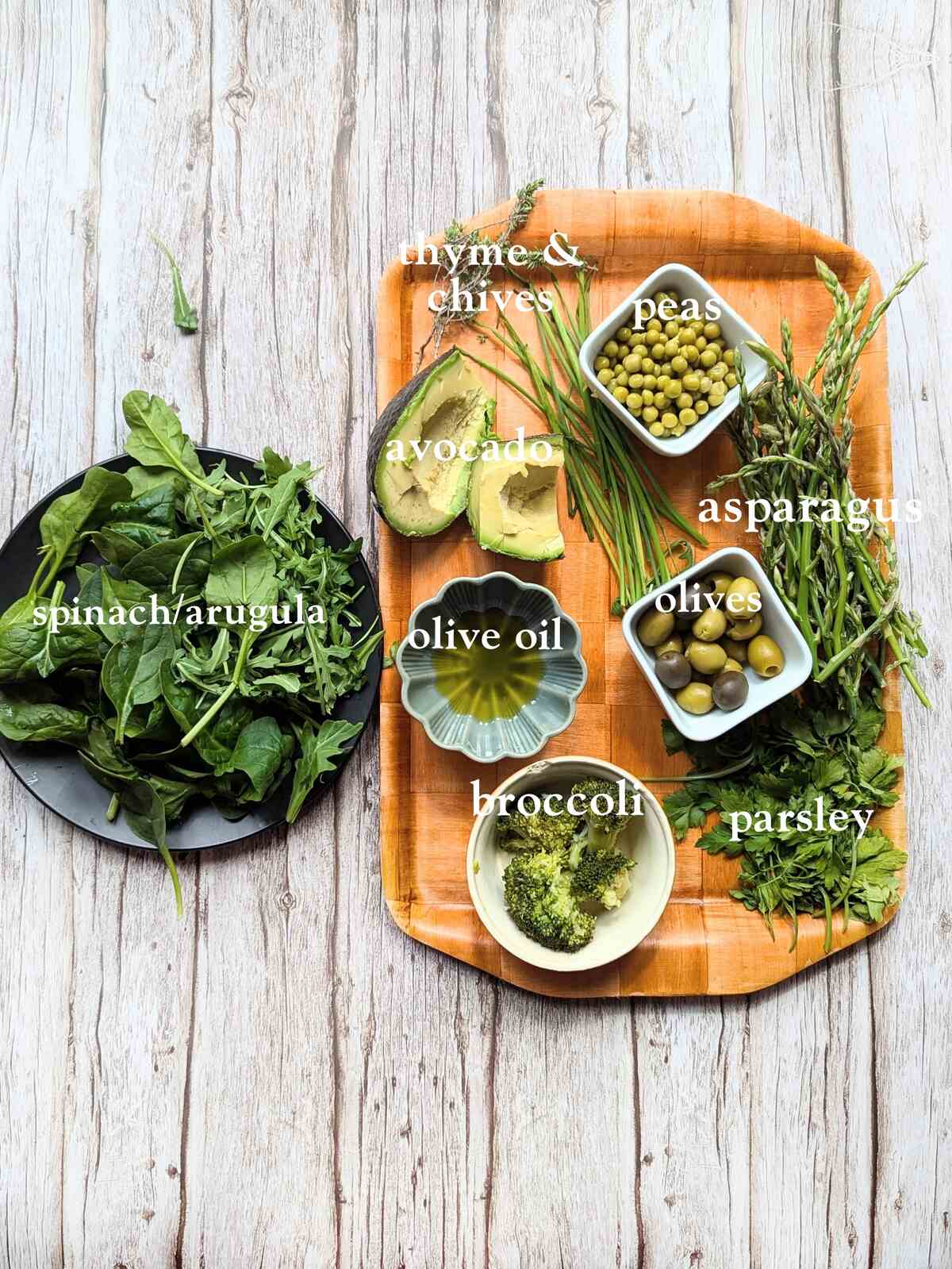 Spring green wild sald ingredients: Assorted fresh vegetables and herbs including spinach, avocado, peas, and broccoli.