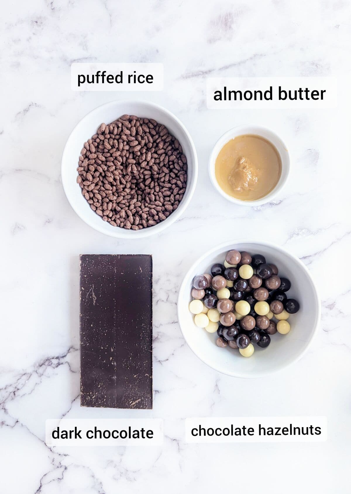 Easter treat ingredients with puffed rice, almond butter, dark chocolate, and chocolate hazelnuts.