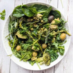 A plate of assorted fresh vegetables, asparaagus and herbs.