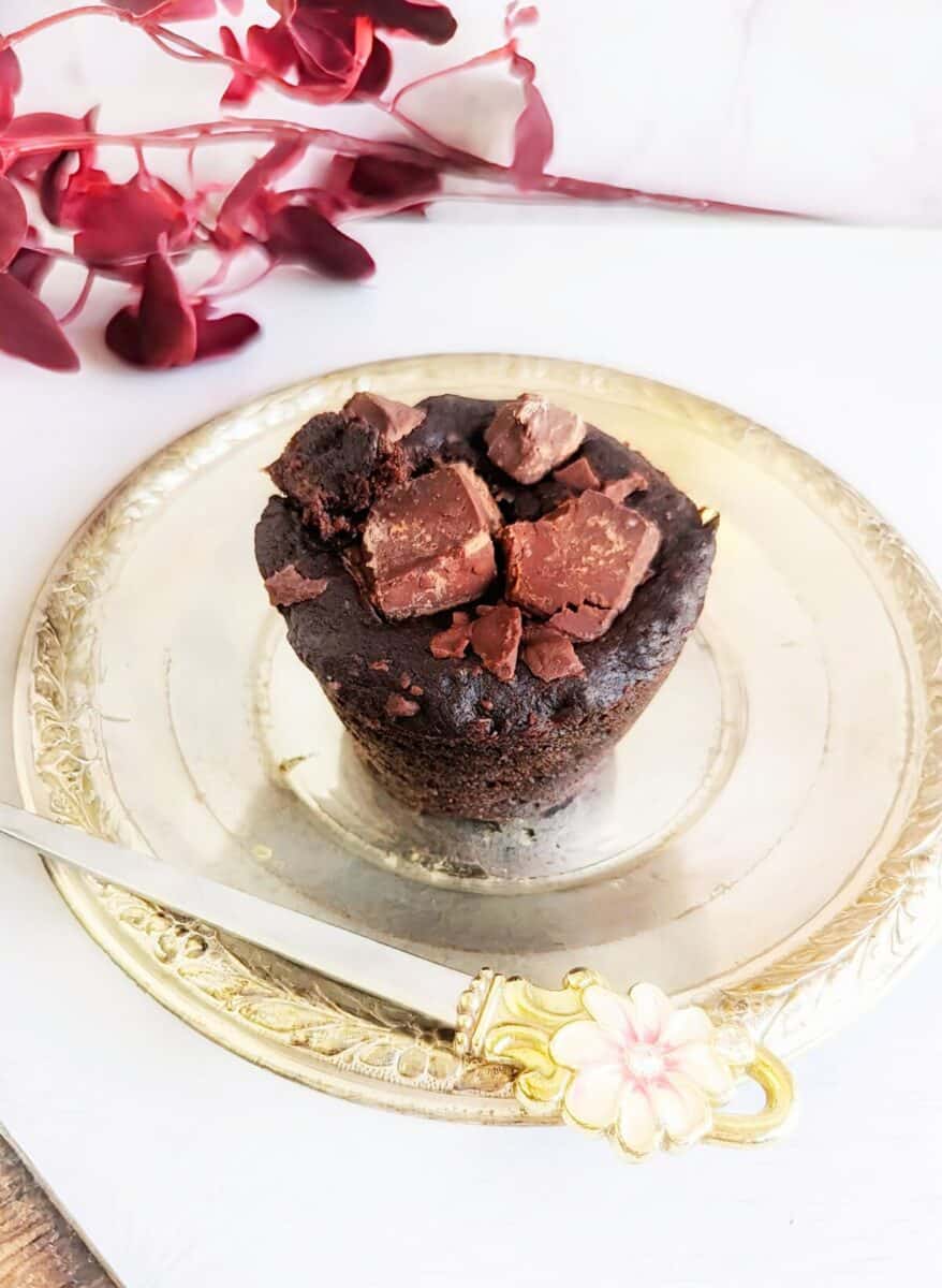 Delicious vegan chunky chocolate banana muffin cakes topped with cacao chunks on a vintage plate.